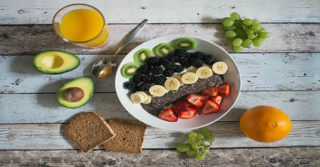 A colorful plate of fresh fruit and vegetables arranged on a table, symbolizing a healthy morning routine.