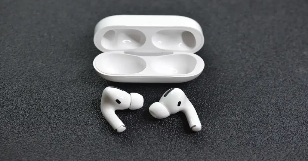 White wireless earbuds with silicone tips are placed on a dark surface, beside an open charging case. The setup conveys a sleek, modern feel. best