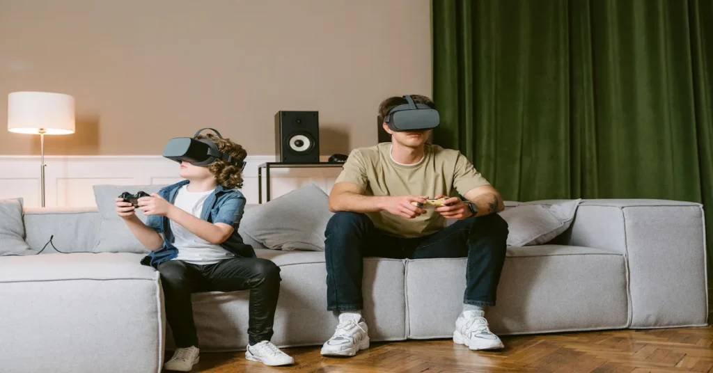 Two men on a couch, each wearing a virtual reality headset, exploring a digital world together.