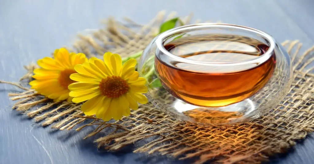 Chamomile herbal tea in a glass cup with yellow flowers—one of the best natural ways to reduce anxiety without pills.