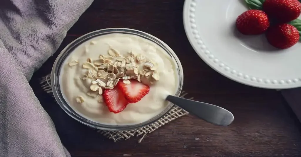 Yogurt topped with fresh strawberries and oats, representing a healthy snack option for hormonal balance.